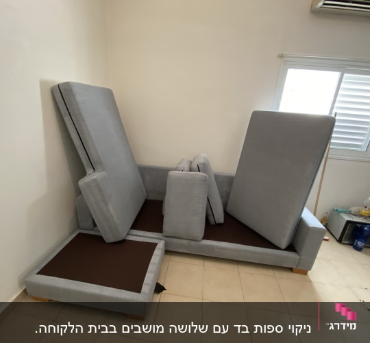 כריות ספה אפורות מונחות לניקוי בחדר